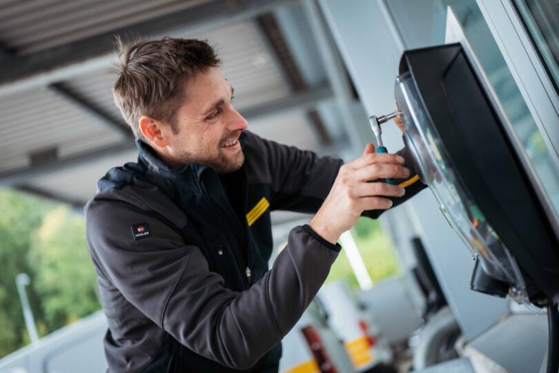 Elektroinstallateur installiert und aktiviert Wallbox-Ladestation für E-Mobilität am Gebäude